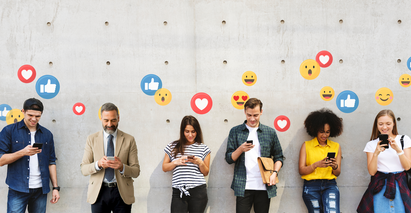 Line of people against a wall interacting with devices while emojis of likes, expressions and thumbs-up float above their heads.